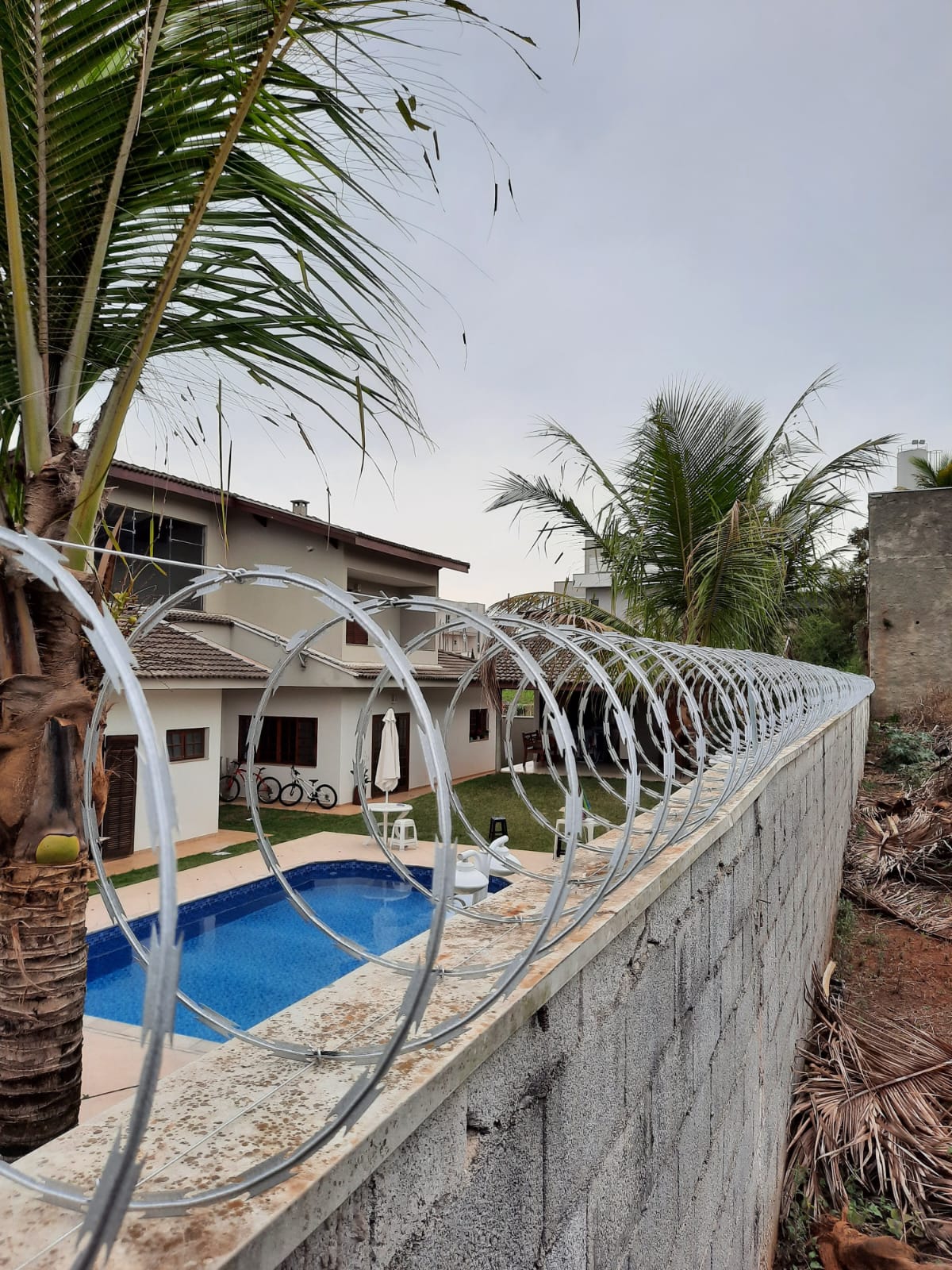 Instalação de concertina em muro de residência de alto padrão com piscina